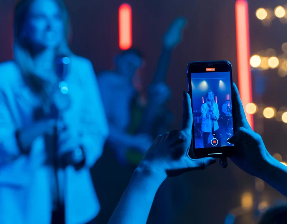 Person taking picture of a singer with a phone